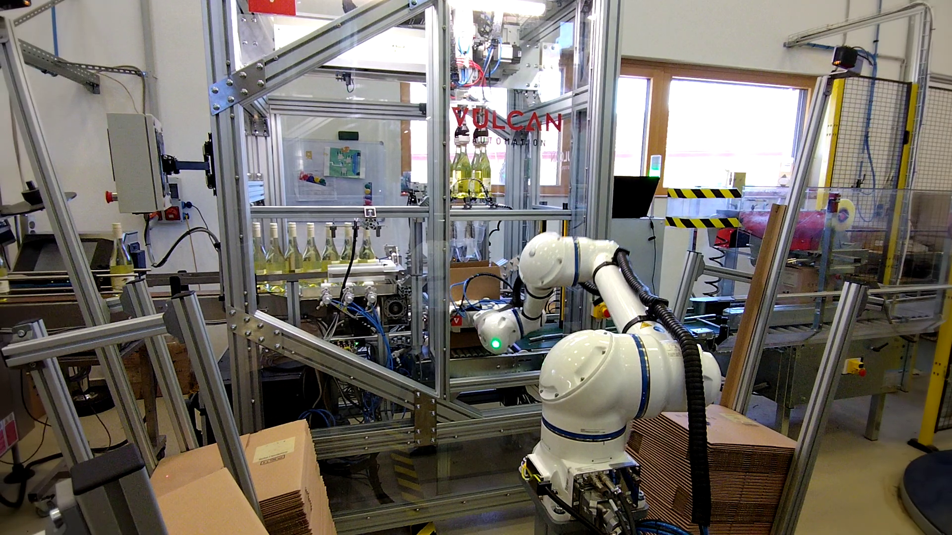 Placing wine bottles into a cardboard box folded by a robot